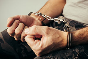 Close-up photo of a man's hands in handcuffs